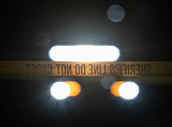 Riverside County Sheriff's Department vehicle lights illuminating crime scene tape at the Aquatic Center in Palm Desert, California at night