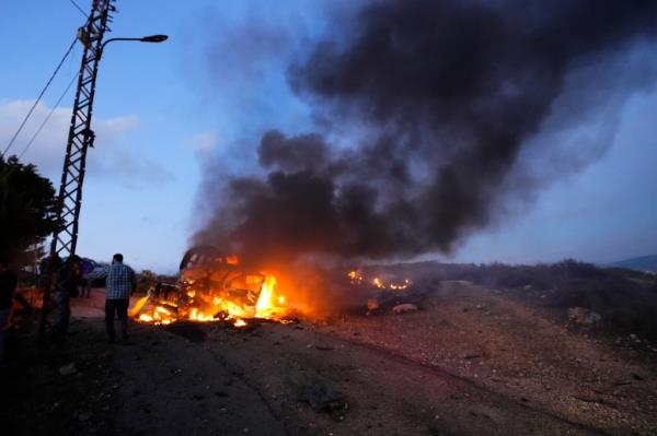 A journalist's car burns after it was hit by Israeli shelling in the Alma al-Shaab border village.
