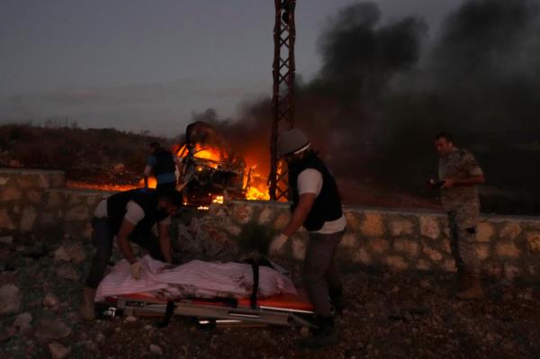 Civil Defense workers remove the dead body of a journalist killed by Israeli shelling Friday.