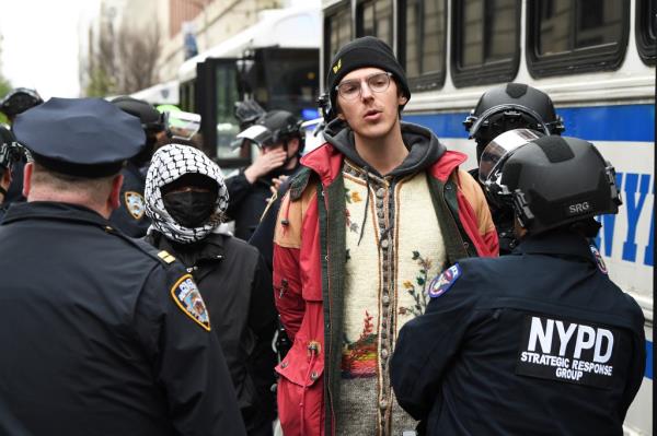 A detained protester is brought o<em></em>nto a bus after the NYPD raided Columbia.