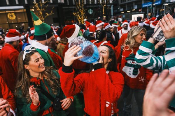 A girl drinking in public during SantaCon.