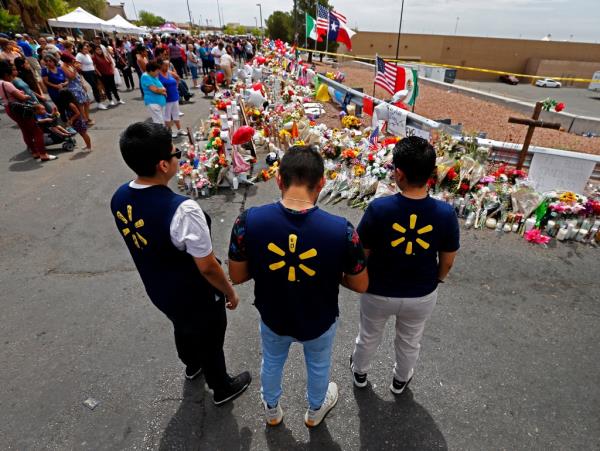 Walmart employees visiting a memorial for the 23 shooting victims outside of the store in El Paso on August 6, 2019.