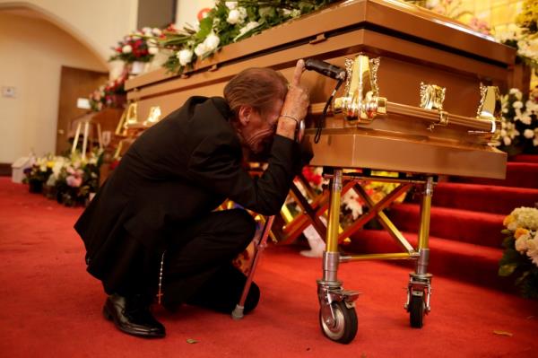 Anto<em></em>nio Basco next to his wife Margie Reckard's coffin at her funeral after she was killed in the Walmart shooting.