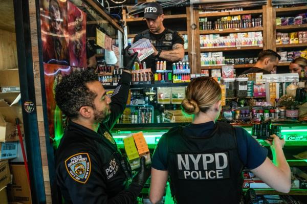 New York City Mayor Eric Adams announcing a crackdown on unlicensed smoke and cannabis shops alo<em></em>ngside a female officer, at New City Smoke Shop on Church Street.