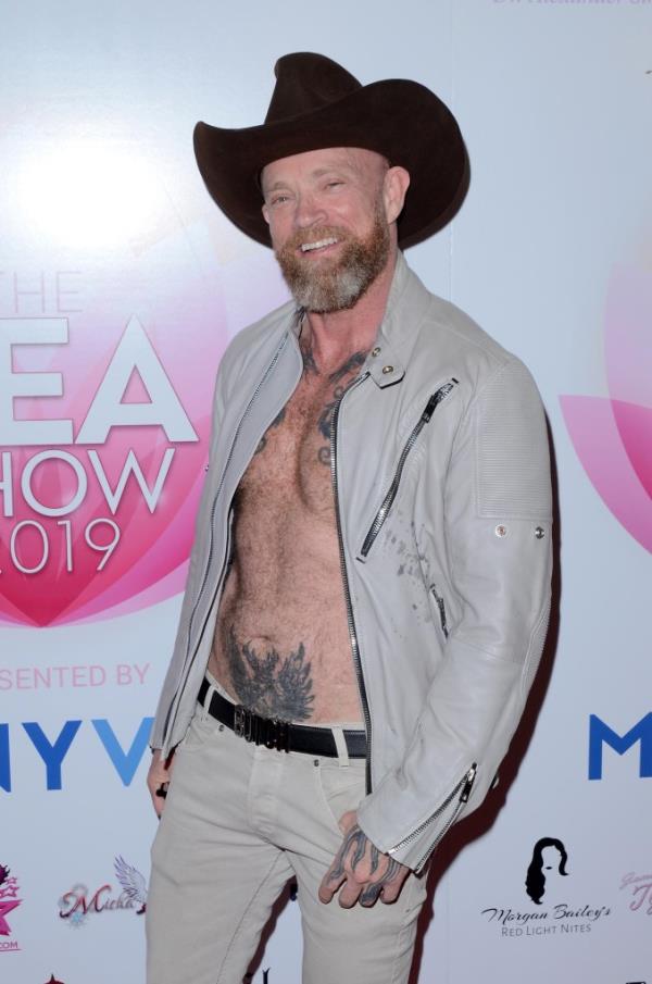 Buck Angel, wearing a cowboy hat and a jacket with no shirt.