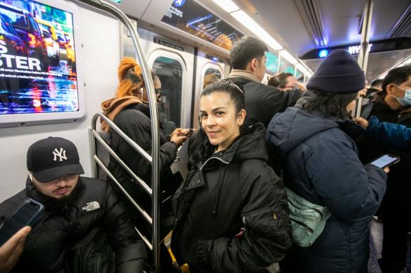 A woman standing on a subway car.