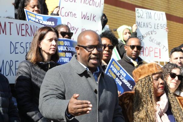 Crowd holding signs at Co<em></em>ngressman Jamaal Bowman's rally against proposed state foundation aid cuts to schools at Benjamin Turner Academy.