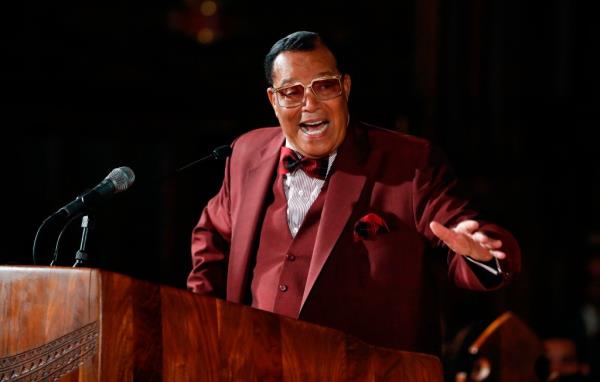 Louis Farrakhan, Nation of Islam leader, speaks at a podium in a red suit and bow tie at St. Sabina Catholic Church in Chicago.
