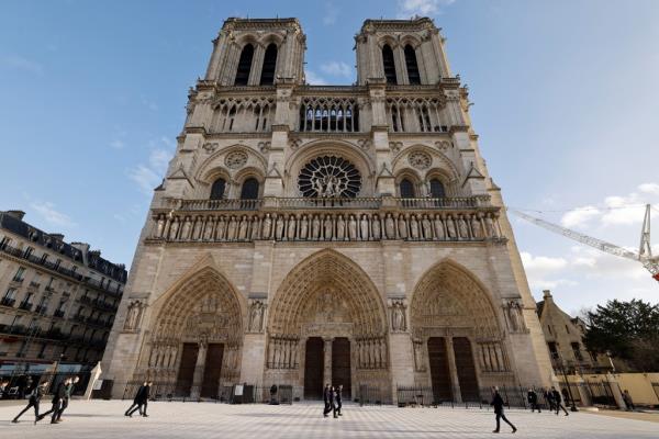People walking in front of Notre-Dame de Paris cathedral, a<em></em>bout to be officially reopened after five years of restoration post-April 2019 fire.