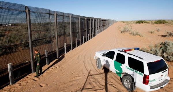 A Border Patrol agent looks along a new section of pedestrian barrier fencing in Santa Teresa, New Mexico.