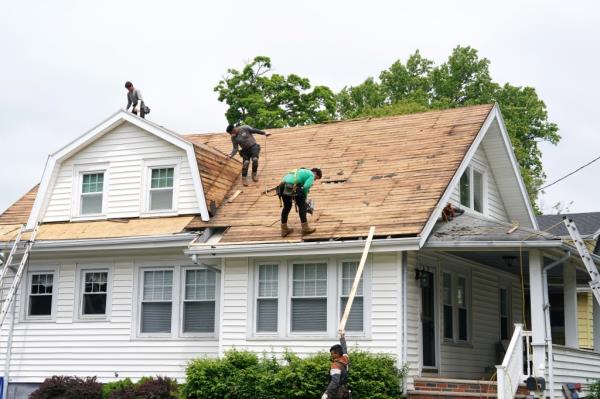 House roof being replaced by workers.