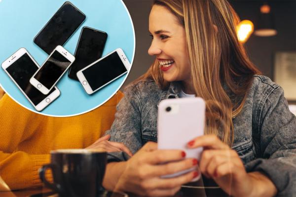 Cheerful young women sitting together at a coffee shop, looking at a mobile phone