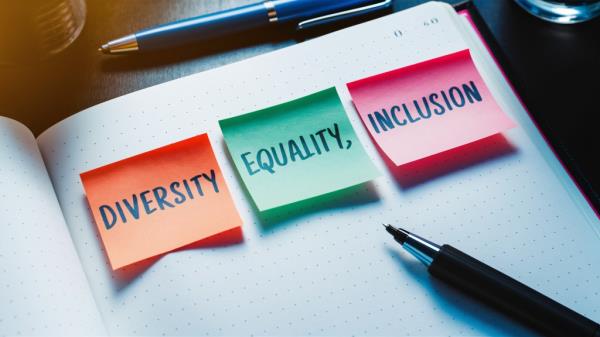 Notepad on a desk with sticky notes discussing Diversity, Equality, and Inclusion concepts