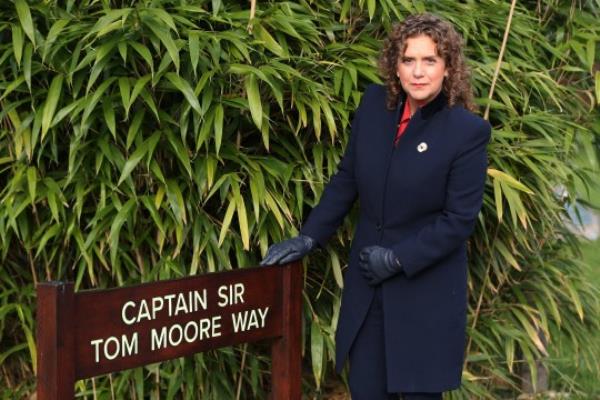 ALREWAS, STAFFORDSHIRE - NOVEMBER 04: Hannah Ingram-Moore, daughter of Captain Sir Tom Moore, poses for a photograph in front of the sign marking the path named in her father's ho<em></em>nour on November 04, 2021 in Alrewas, Staffordshire. Ms Ingram-Moore, a daughter of the World War II veteran who famously raised mo<em></em>ney for the NHS amid the Covid-19 pandemic, visited the Arboretum for the first time to inspect the path named in his honour. If visitors walk Captain Sir Tom Moore Way and take a co<em></em>nnecting path to the Burma Star Memorial - an award given to Captain Tom - they will cover 250 metres, the same distance as Captain Tom walked each day for his fundraising challenge. (Photo by Charlotte Tattersall/Getty Images)