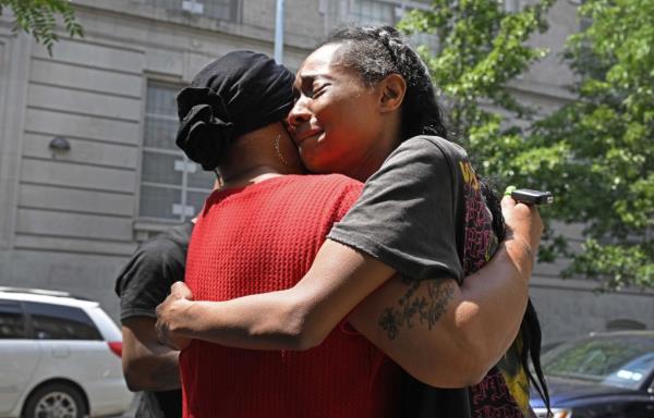 Tiffany Grant, (pictured, black shirt) the mother of Jasai Guy, getting comforted near a memorial that was set up for her son