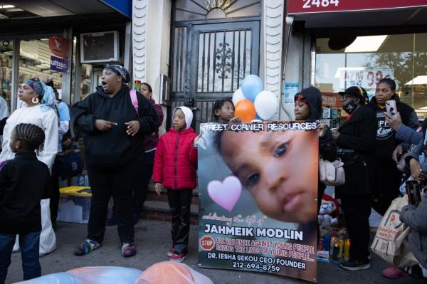 Young activists hold a poster of Jahmeik Modlin 