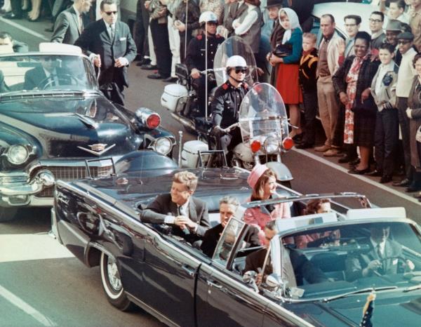 President John F Kennedy, First Lady Jacqueline Kennedy, Texas Governor John Connally, and others smile at the crowds lining their motorcade route in Dallas, Texas, on Nov. 22, 1963, minutes before JFK was shot.