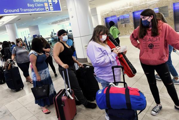 Travelers wearing face masks waiting in line at the Southwest Airlines ticket counter at Orlando Internatio<em></em>nal Airport after TSA extends mask mandate
