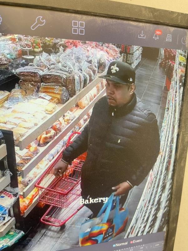 A man holding shopping cart in a grocery store and a shopping bag in a supermarket