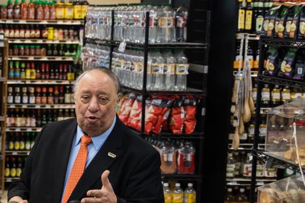 John Catsimatidis standing in front of supermarket shelves co<em></em>ntaining water, chips and sauces
