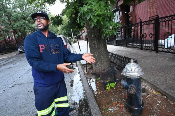 Je-Quan Irving, 47, at the community goldfish pond he and other men in Bed-Stuy set up around a leaking, decommissio<em></em>ned fire hydrant on Hancock Street.