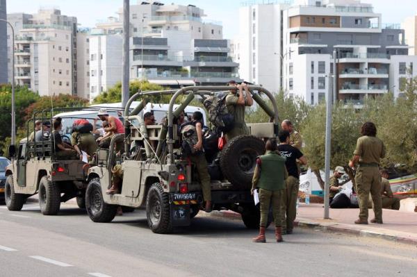 Israeli army reservists are transported in military vehicles to join the their army ba<em></em>se
