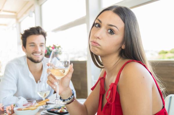 An annoyed woman on a date with a small guy. 