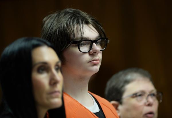 Ethan Crumbley in glasses and an orange prison jumpsuit in court. 
