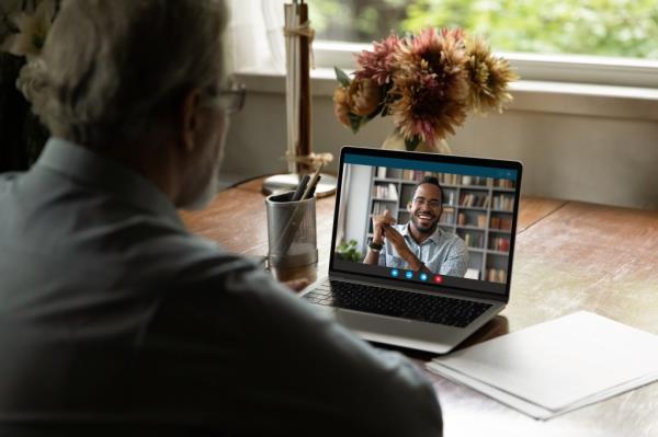 Stock image of person using video chat on laptop.