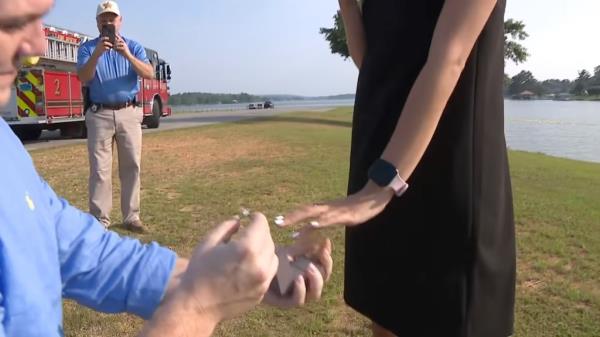 He places the engagement ring on Bell's finger