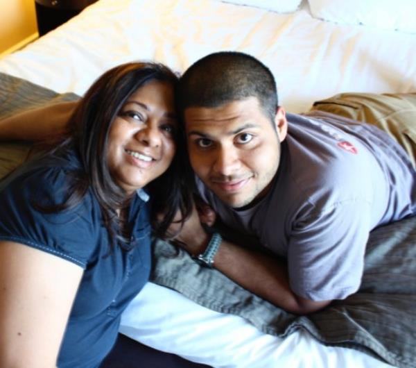 Vidhu and Rudy relaxing at home, both smiling at the camera.