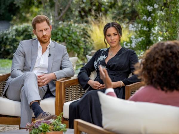 Prince Harry and Meghan, Duchess of Sussex, sitting in a chair during their interview with Oprah Winfrey