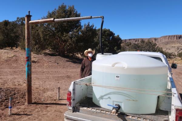 Phillip Yazzie waits for a water drum in the back of his pickup truck to be filled in Teesto, Arizona, on the Navajo Nation.