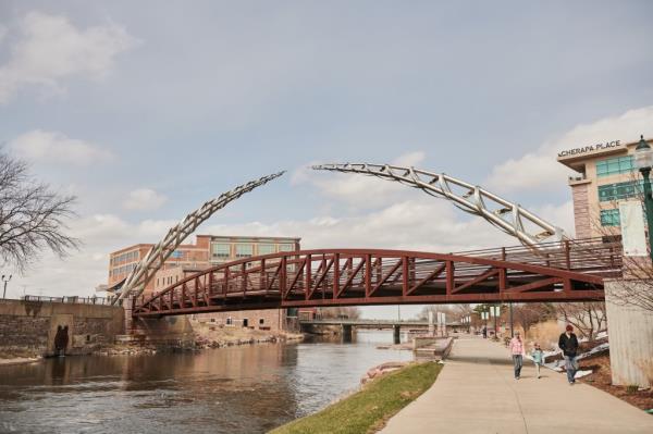 Pedestrians pass in front of the Arc of Dreams statue in Sioux Falls, South Dakota, U.S., on Wednesday, April 15, 2020.