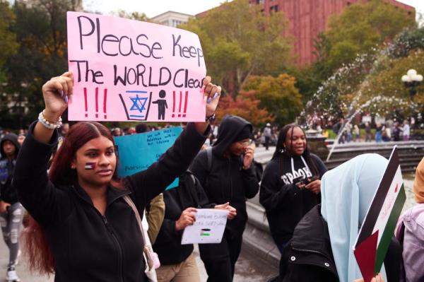 A protestor holds a poster with the message 