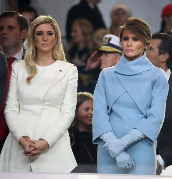 First lady Melania Trump (R), stands with Ivanka Trump as a parade passes the inaugural parade.