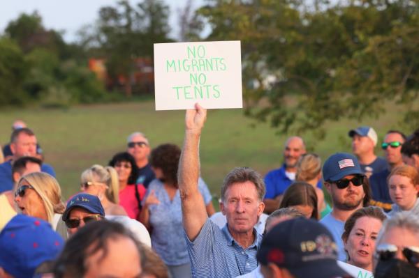 People attend an anti-migrant protest