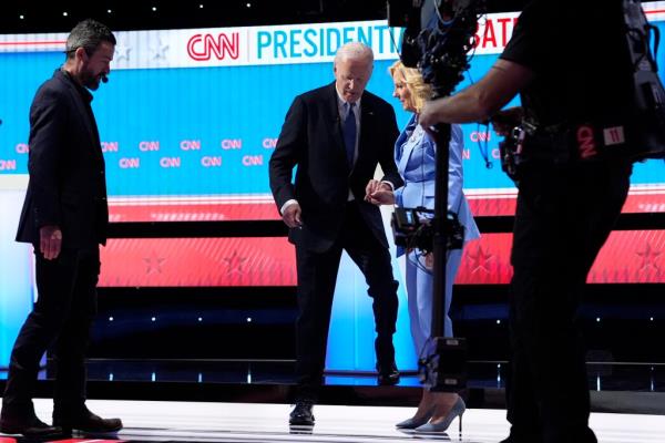Jill Biden assists Joe Biden as he steps off the stage after the debate.