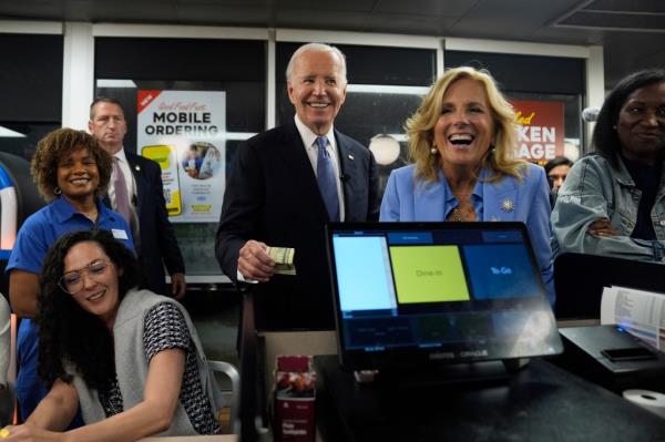 President Joe Biden, center, and first lady Jill Biden, second from right, pay for a purchase as they greet supporters at a Waffle House in Marietta, Ga., Friday, June 28, 2024.
