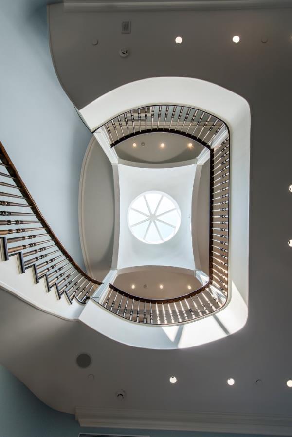 Spiral staircase winding through the interior of 160 East 83rd Street Real Estate property, showcasing a round window.
