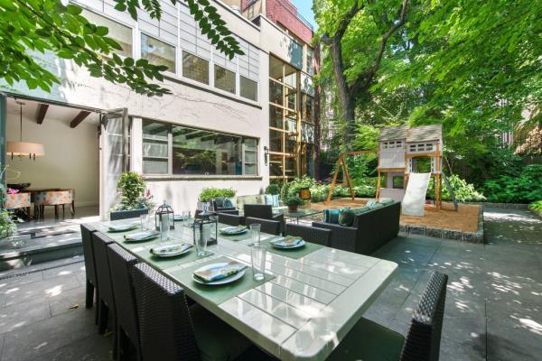A table set with plates in the triple-wide rear garden of the real estate property at 160 East 83rd Street