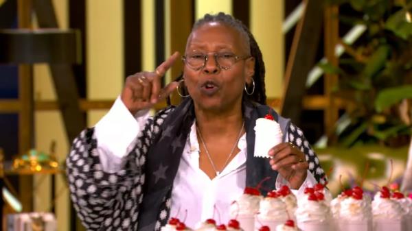 Whoopi Goldberg holding up a peace sign while discussing her claim that an NYC bakery refused to serve her due to her political beliefs