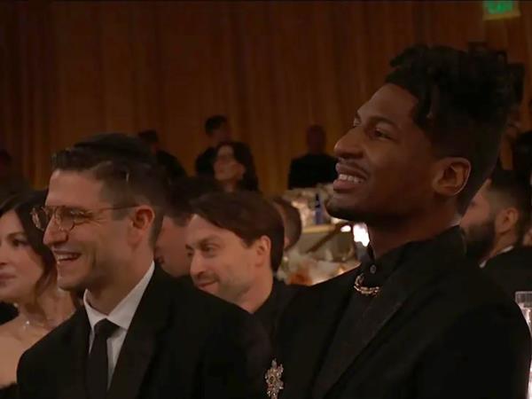 The Golden Globes crowd laughing, including Jon Baptiste. 