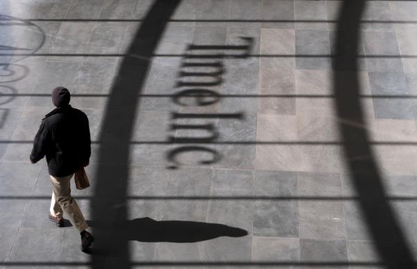 A person walking past the Time Inc. logo in the lobby of their office headquarters in lower Manhattan, New York City