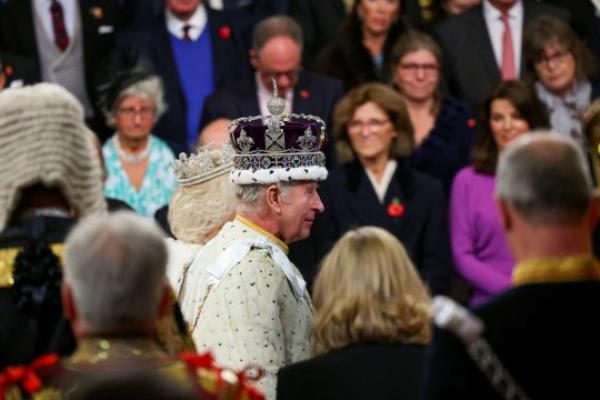 King Charles III and Queen Camilla depart the State Opening of Parliament in the House of Lords at the Palace of Westminster in London. You can see their heads and crowns amo<em></em>ngst the crowd.