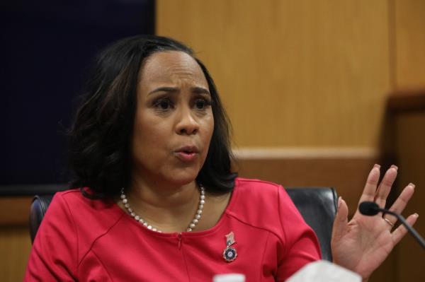 A photo of Fani Willis wearing a vivid red dress in court.