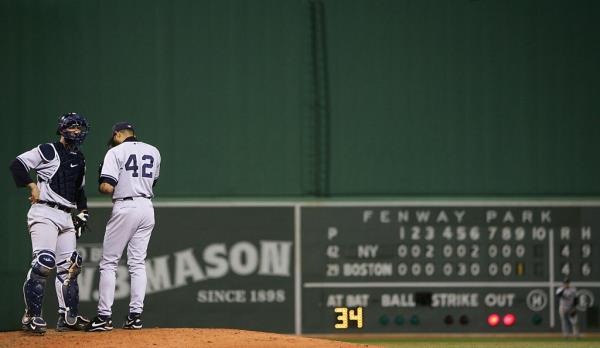 Catcher Jorge Posada #20 of the New York Yankees meets with pitcher Mariano Rivera #42 after Rivera gave-up the game-tying run on a single by Bill Mueller #11 in the ninth inning