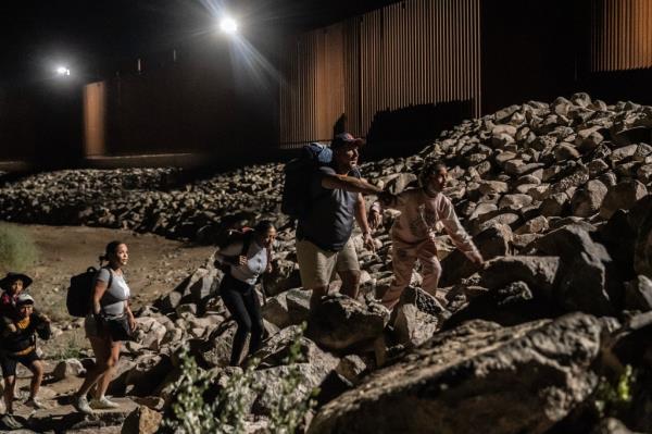 Migrants arriving at the border wall near Yuma, Arizona on August 6, 2023.
