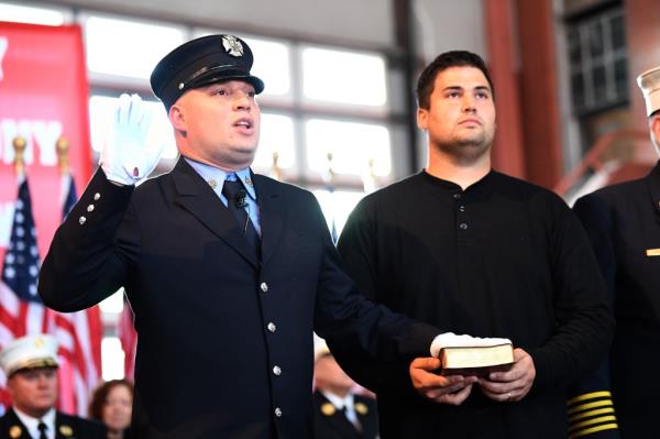 Firefighter Christopher M. Otten is sworn in by his brother Johnathan Otten, also with the FDNY