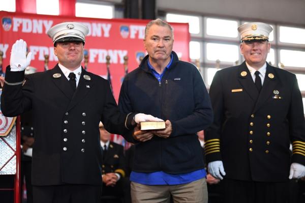 Newly-promoted Capt. Thomas Riches is sworn in with his retired firefighter father, Jimmy Riches Sr.